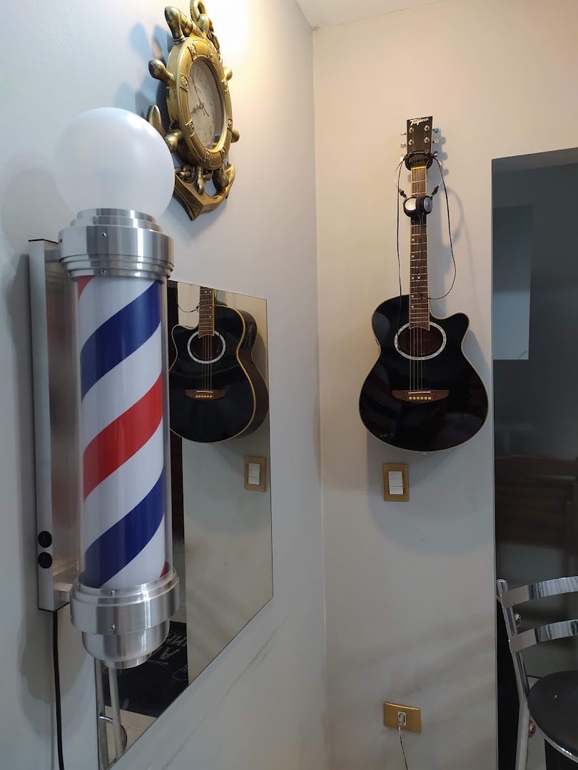 Detalhe da decoração da barbearia, com barber pole e violões na parede